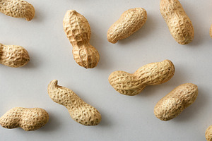 Peanuts in shell showing their shape on a white table., a Food & Drink Photo by Davizro's Market