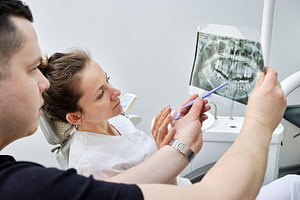 Professional dentist showing panoramic dental X-ray to a female colleague. Medi, a Health & Medical Photo by Rohan Photography