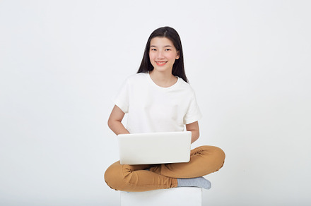 woman sitting using laptop sitting on gray background, a Person Photo by 1981 Rustic studio kan