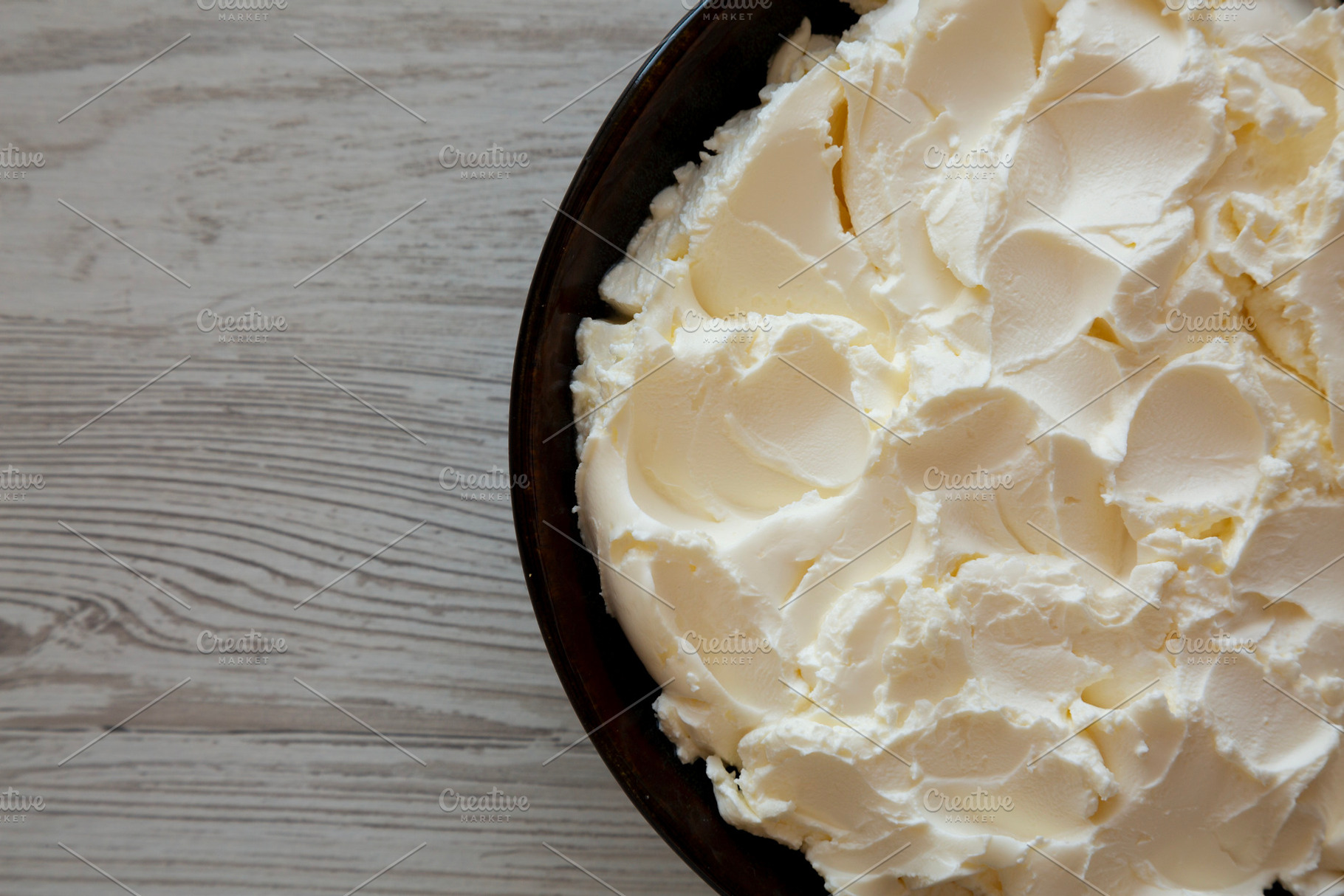 Organic White Mascarpone Cheese in a Bowl, top view. Copy space., a Food & Drink Photo by LiudmylaChuhunova
