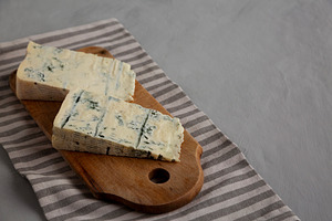 Blue cheese Gorgonzola on a Wooden Board, side view. Copy space., a Food & Drink Photo by LiudmylaChuhunova