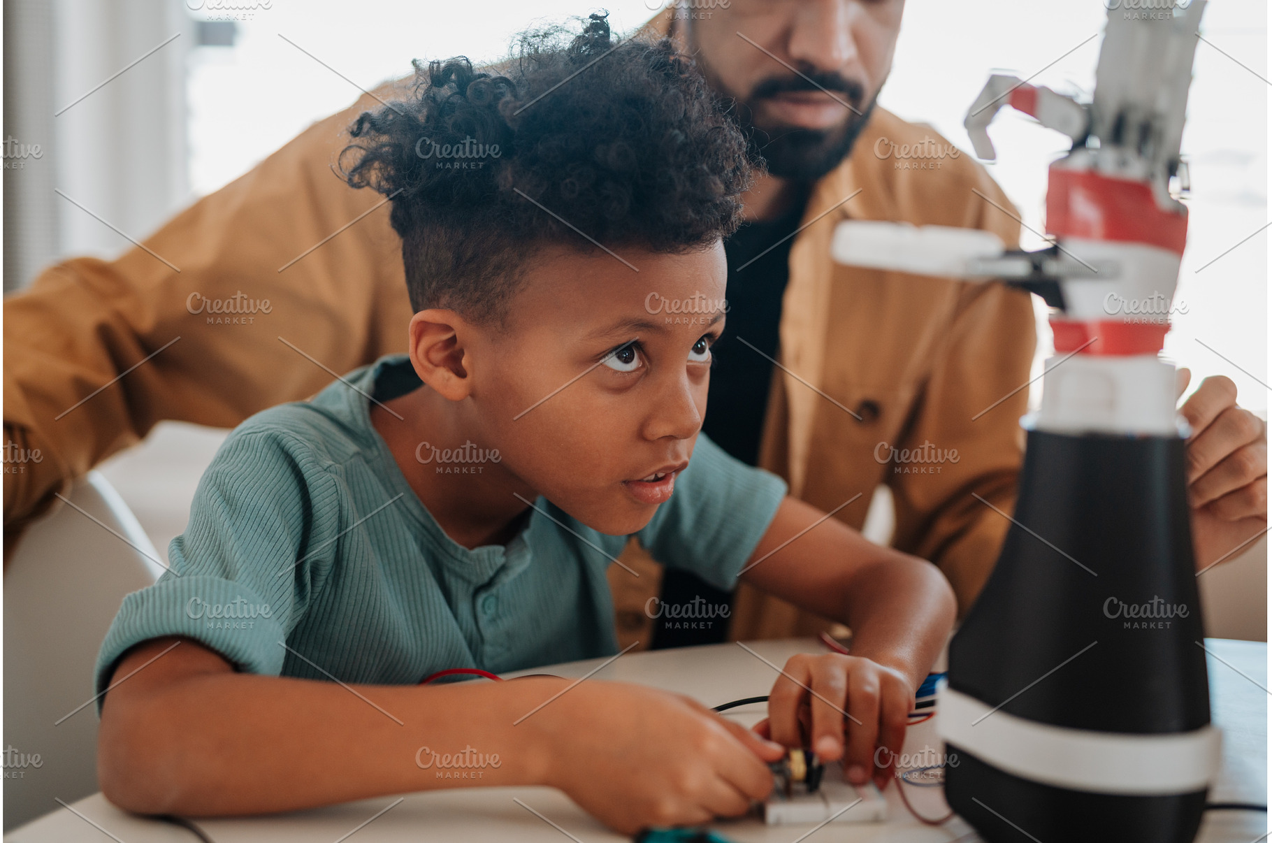 Father and son working on robotic, a Technology Photo by HalfPoint