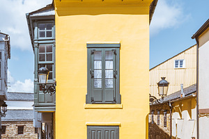 Yellow house on cobblestone street, an Architecture Photo by SkyNext