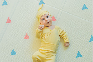 Adorable baby in a yellow hat lying, a Person Photo by Elizaveta Galitskaya