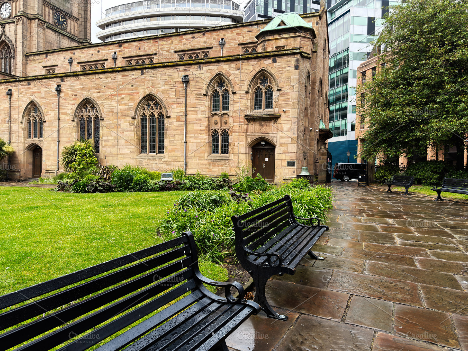Quiet churchyard with wet benches and stone path in Liverpool, U, a Photo by AS photostudio