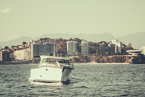 Boat on sea with city skyline, a Transportation Photo by SkyNext
