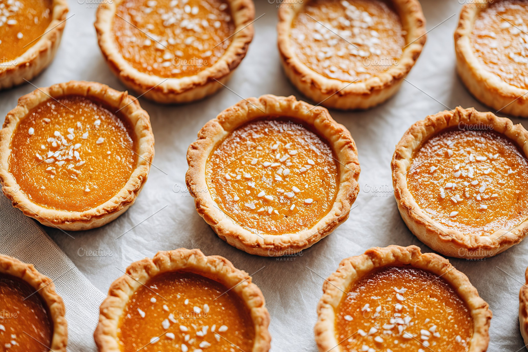 Delicious pumpkin tarts arranged on a baking tray ready for serving, a Food & Drink Photo by AlyaAnd