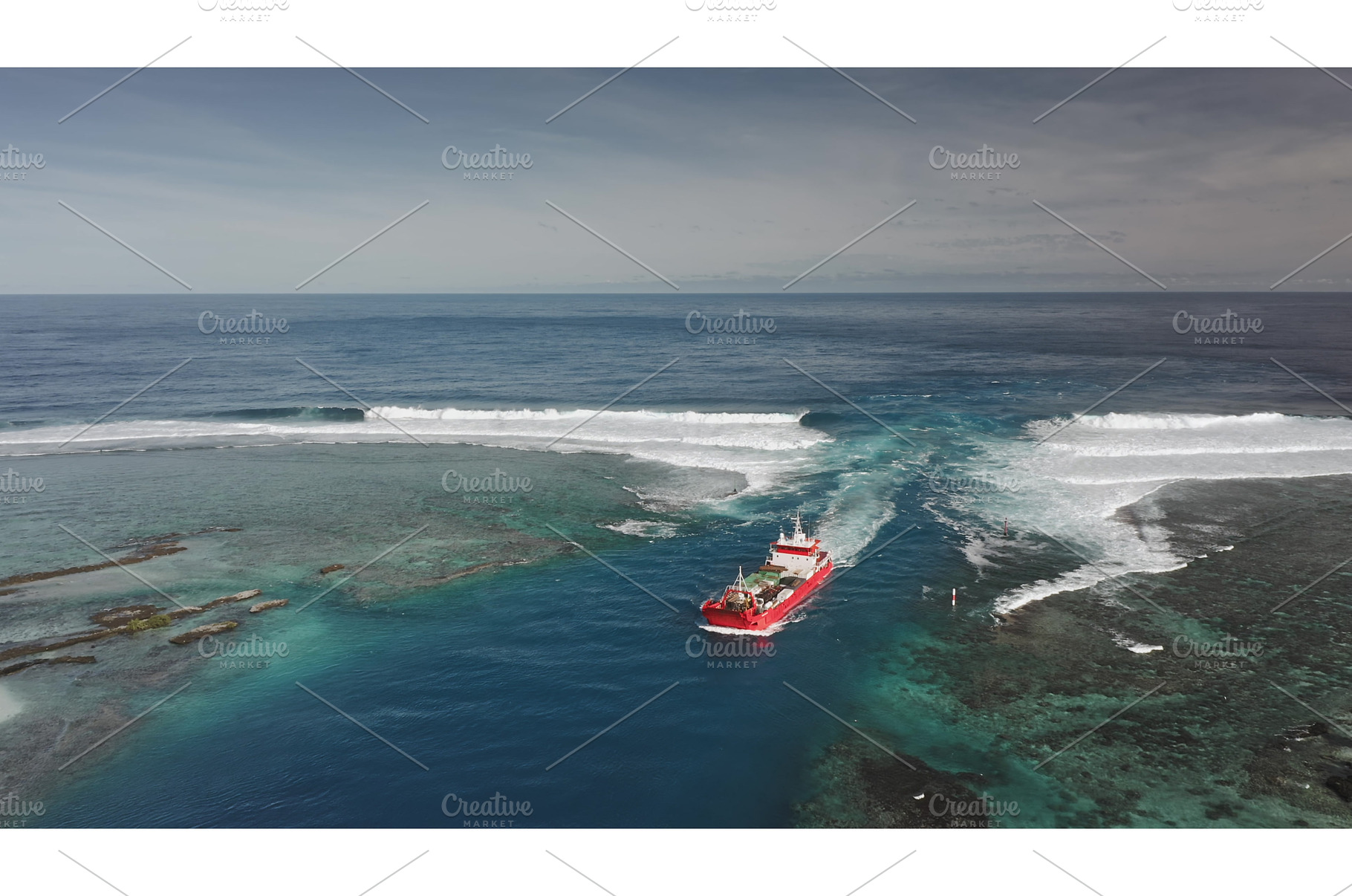 Red cargo ship sailing near a coral, a Transportation Photo by Goinyk