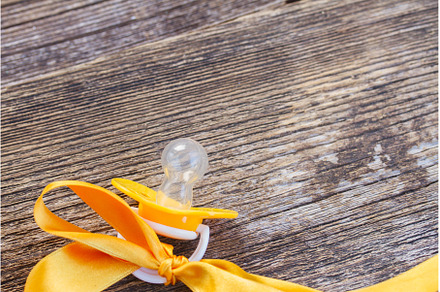 baby pacifier on wooden table, an Abstract Photo by Neirfy