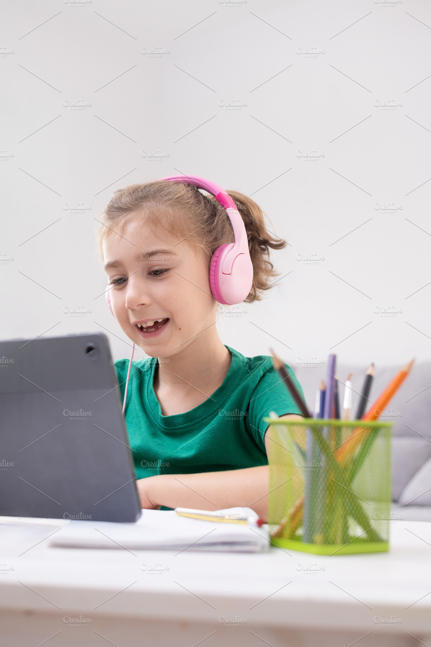 Young Girl Watching Tablet with pink headphones, a Person Photo by etorres69