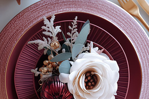 Festive Christmas dining table set with deep red plates, golden cutlery, and an, a Food & Drink Photo by Anneleven