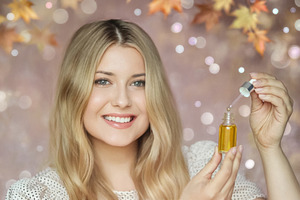 Young woman holding a dropper bottle with oil serum, preparing t, a Person Photo by Studio ANNA