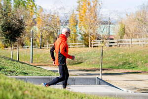 Senior man running up stairs in an outdoor park setting, a Sports & Recreation Photo by RF Images