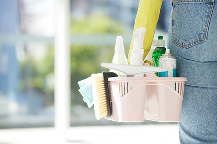 Person with basket of product, in house or room working for cleaning service company. Worker with brush, spray and chemical cleaner in hand, for spring cleaning home, kitchen or office building, a Photo by Peopleimages.com