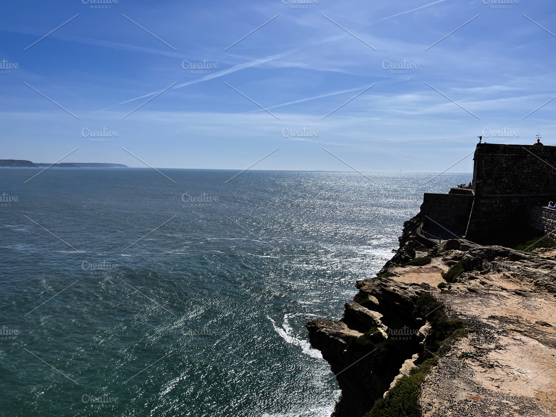 Dramatic coastal view of cliffs and ocean under a clear sky in Nazare, a Photo by AS photostudio