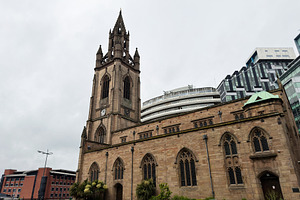 Historic Gothic church with clock tower and modern city building