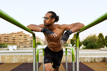 Male athlete resting on calisthenics