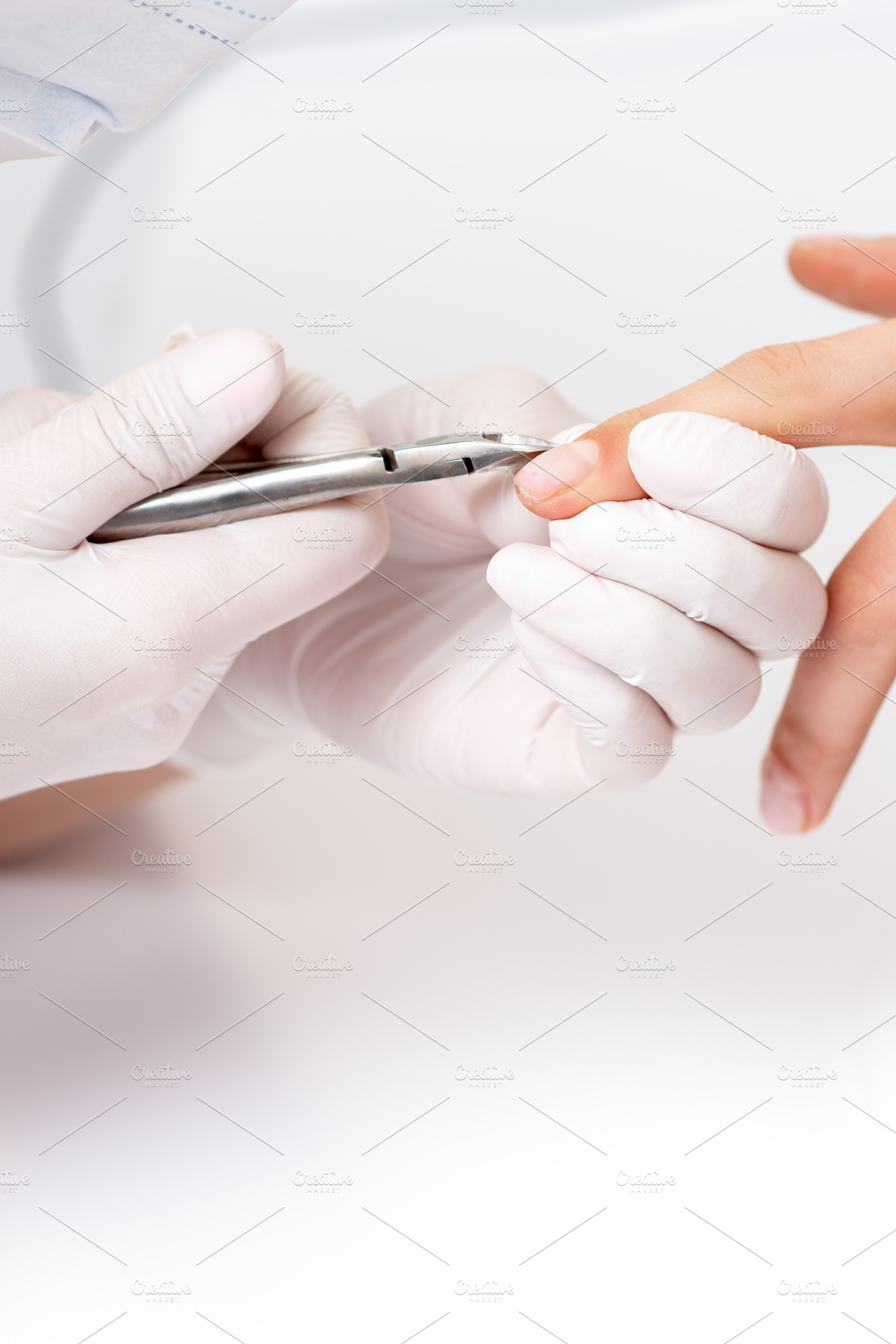 Close up of manicurist using manicur containing manicure, nail, and scissors, a Beauty & Fashion Photo by okskukuruza