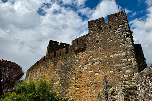 Historic Tomar castle with medieval architecture under a dramatic sky in Portug, a Photo by AS photostudio