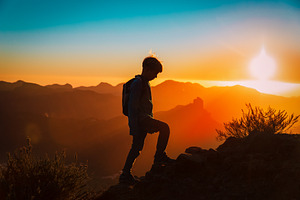 child in sunset mountains