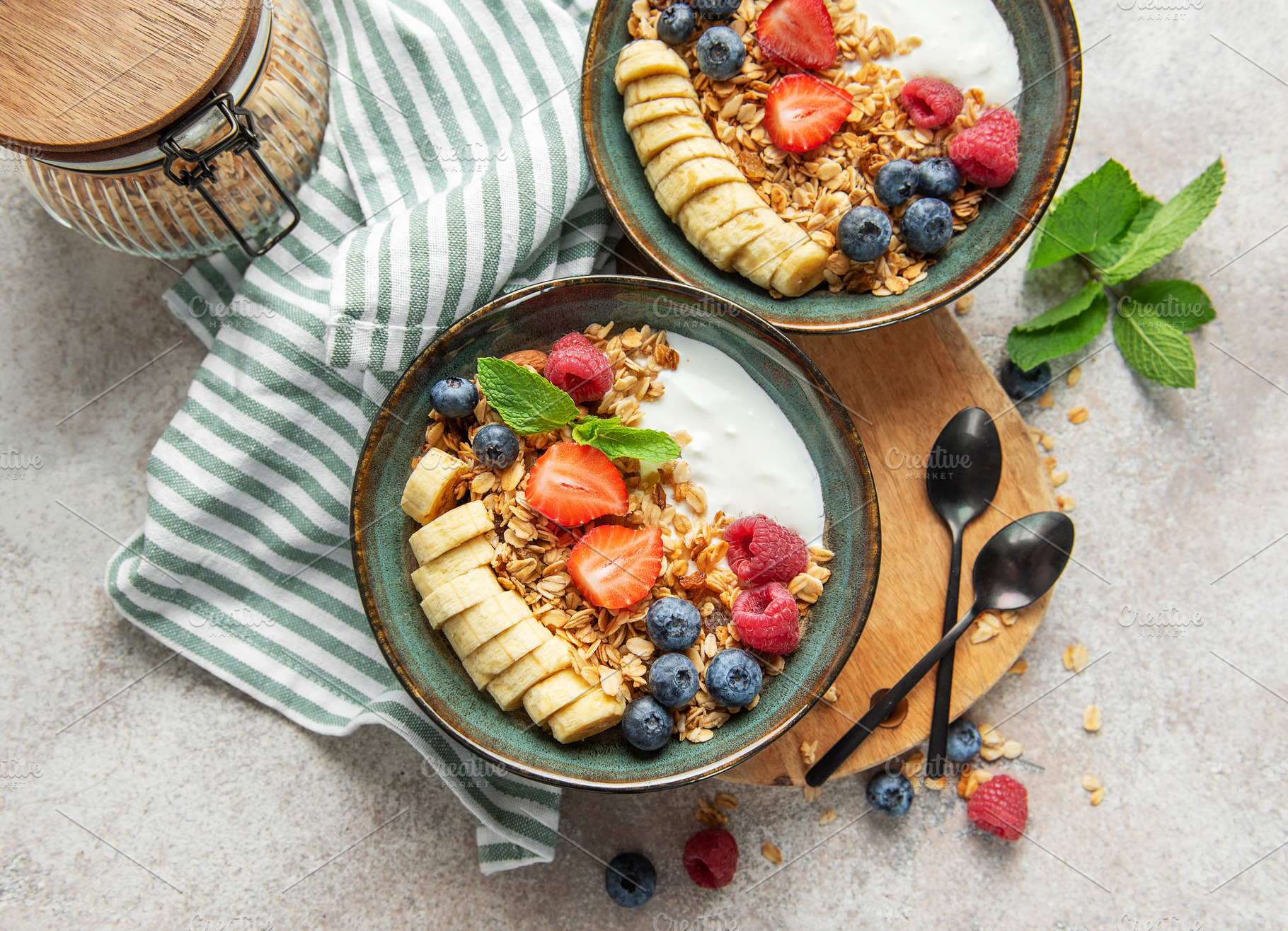 Healthy breakfast bowls with yogurt, granola, banana, and berrie, a Food & Drink Photo by Olena Rudo