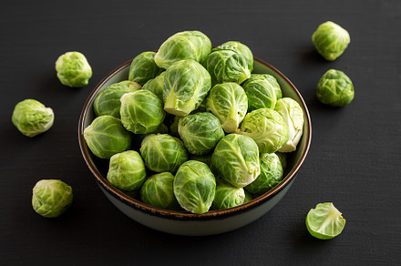 Raw Organic Brussel Sprouts in a Bowl on a black background, sid, a Food & Drink Photo by LiudmylaChuhunova