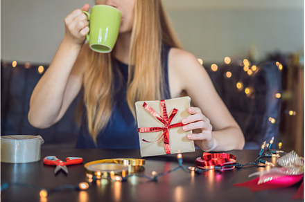 Young woman is packing presents, a Holiday Photo by Elizaveta Galitskaya