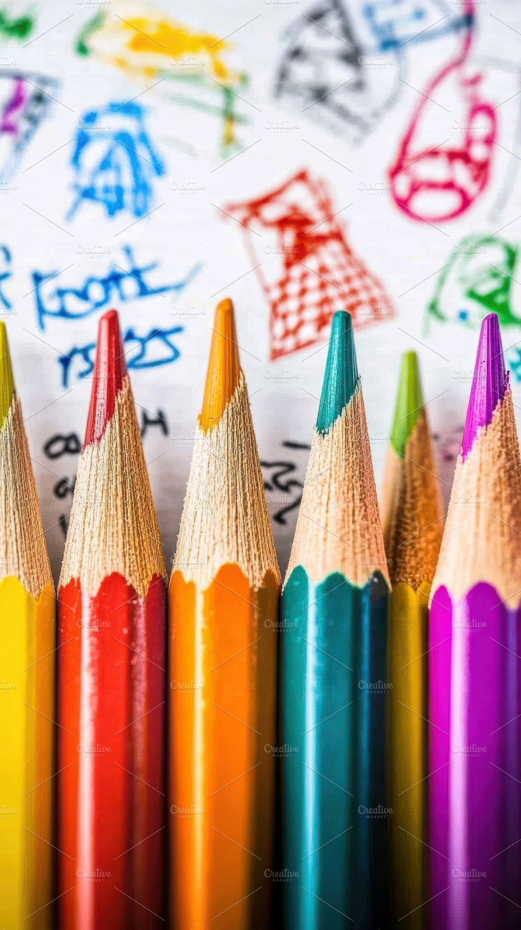 Colorful pencils on child's drawing, a Photo by Pixeness Studio