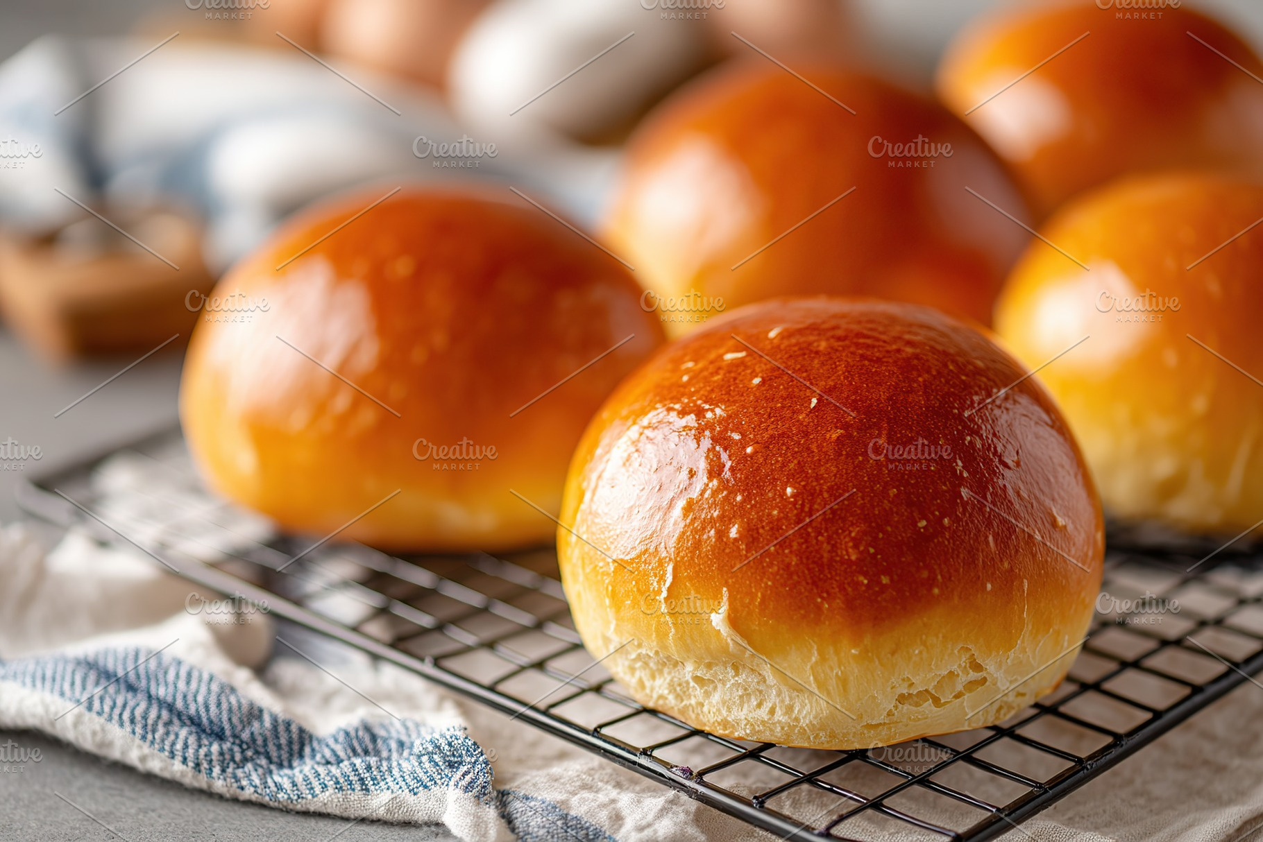 Fresh brioche buns with shiny egg wash cooling on a wire rack in a cozy kitchen, a Food & Drink Photo by AlyaAnd