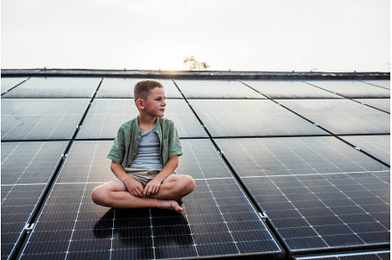 Cute boy sitting on roof with solar