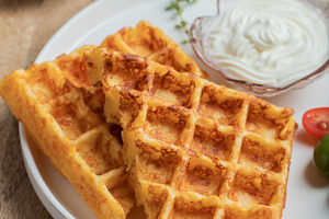 Crunchy waffle fries with sour cream dip served in a basket, a Food & Drink Photo by Budarinphoto