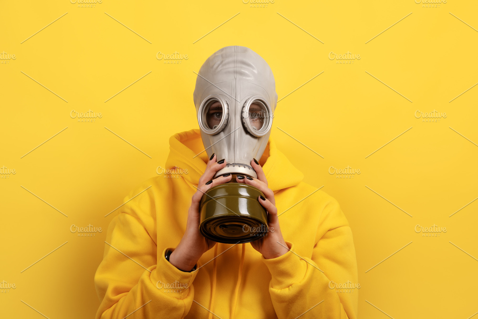 Individual wearing a gas mask and yellow hoodie standing against, a Person Photo by Ales Munt