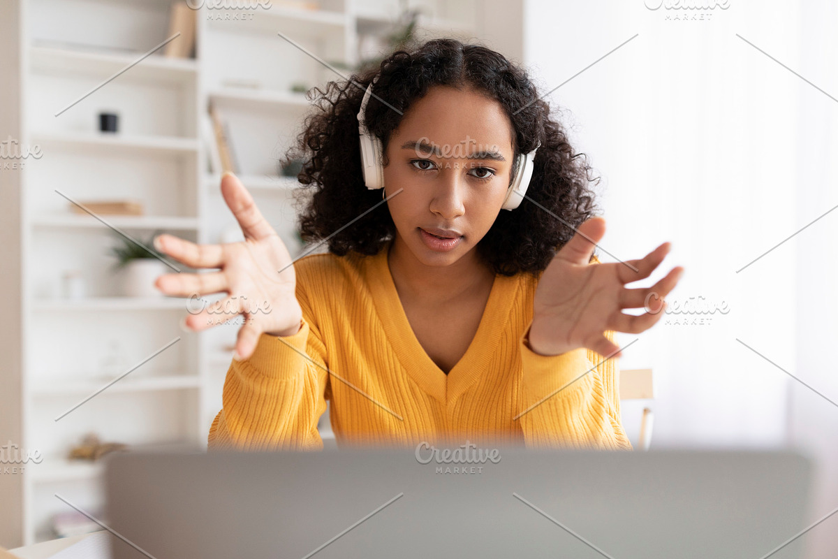Young African American woman in headset having online meeting on laptop compute, a Photo by Prostock-Studio (Photo 2 of 2)
