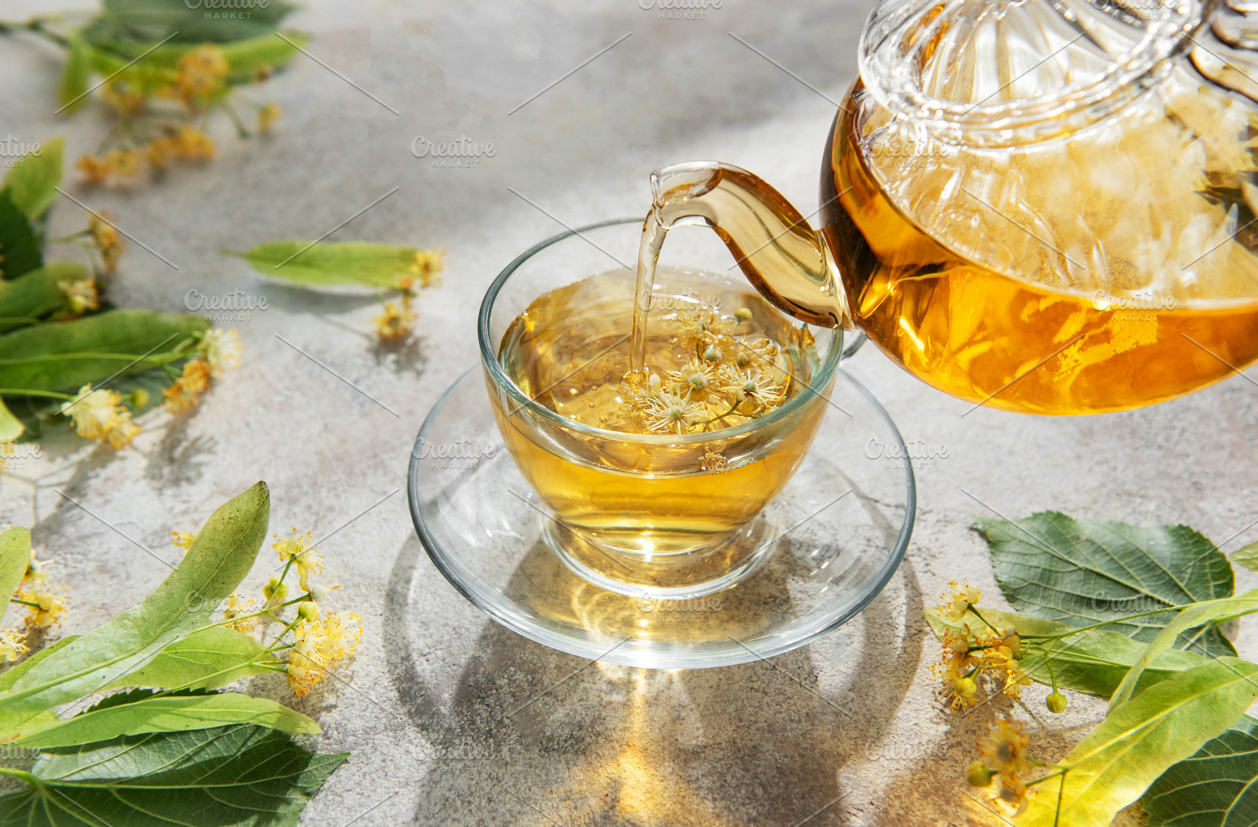 Pouring linden tea into glass cup for relaxation, a Food & Drink Photo by Olena Rudo