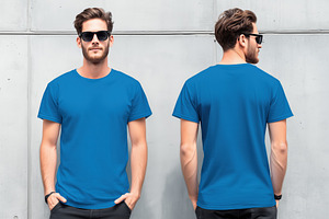 A young man wearing a blue t-shirt mockup and sunglasses, standing against a co, a Shirt Mockup by Textures & Backgrounds