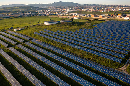 Solar panel farm located in a rural area with rolling hills and small towns nea