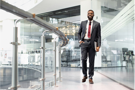 Positive black manager walking by, a Person Photo by Prostock-Studio