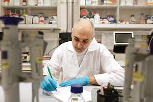 Senior Scientist Writing Notes in a, a Health & Medical Photo by Perpis