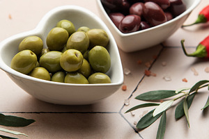 Heart shaped bowls containing green and black olives, olive bran, a Food & Drink Photo by Olena Rudo