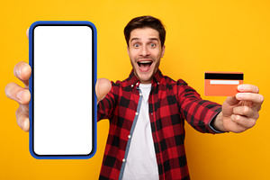 Excited mman showing blank cellphone screen and credit card