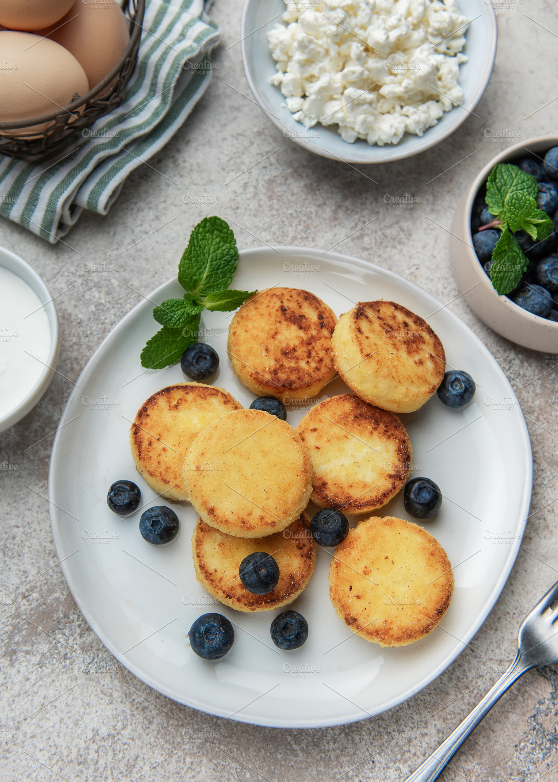 Syrniki cottage cheese pancakes with fresh blueberries and mint, a Food & Drink Photo by Olena Rudo