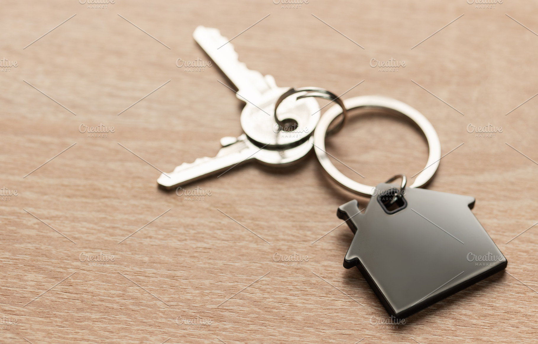 House keys with house shaped keychain on wood, a Business Photo by Olena Rudo