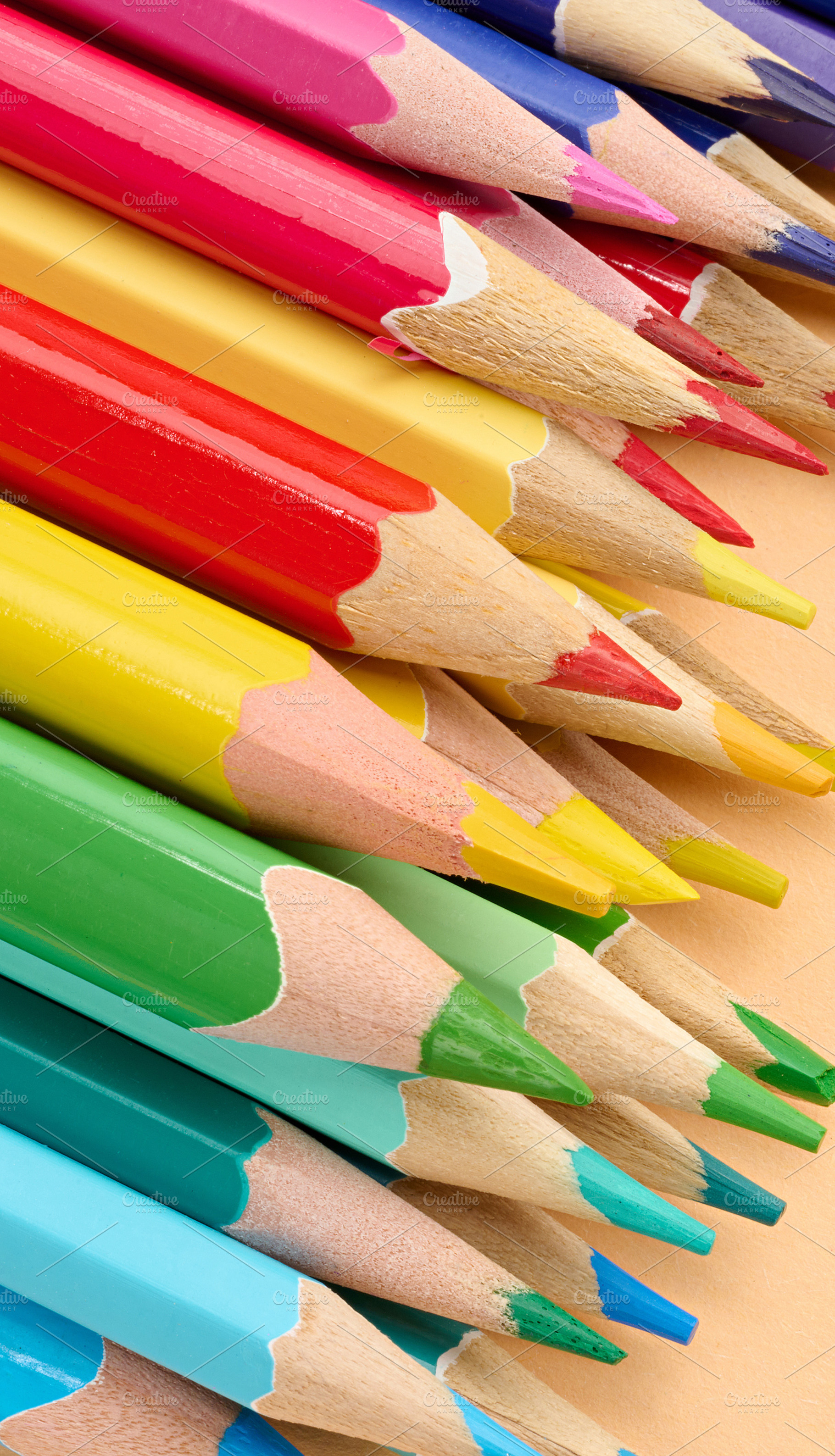 Multicolored wooden pencils stacked on a beige background, a School & Education Photo by ndanko