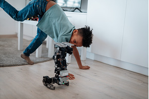 Boy having fun with small robot at, a School & Education Photo by HalfPoint