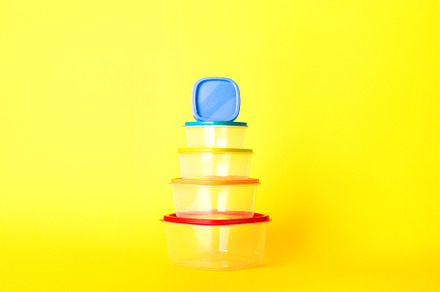 Transparent plastic containers with colorful lids stacked in a p