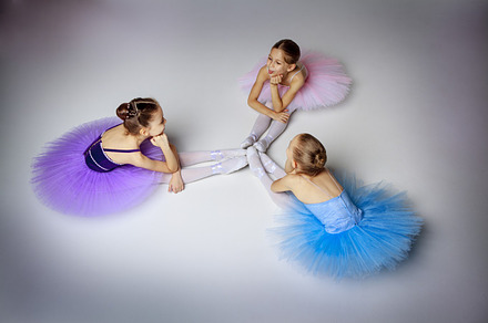 Three little ballet girls sitting in tutu and posing together stock photo, a Person Photo by Volodymyr Melnyk
