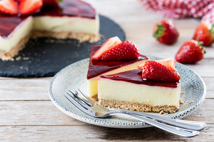 Slice of cheesecake with strawberries on wooden table, a Food & Drink Photo by etorres69