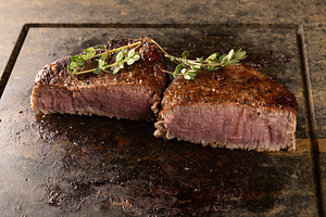 Sizzling medium rare filet mignon steaks, a Photo by Grafvision photography