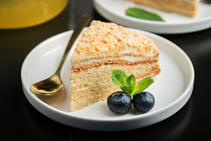 Medovik. Honey cake made from honey cakes with whipped sour cream, decorated wi, a Food & Drink Photo by Budarinphoto