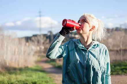 Young woman athlete takes a break, drinking water, out on a run on a hot day, a Person Photo by 2Design